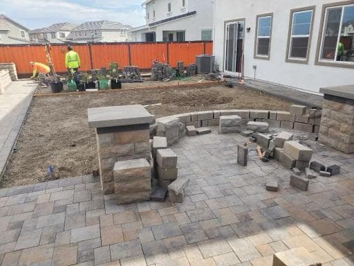 picture of a backyard deck being built and designed with stone pavers